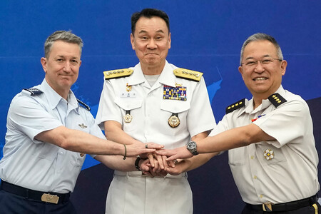11日、ソウルで握手をする米軍のケイン統合参謀本部議長(左)、韓国軍の金明秀合同参謀本部議長(中央)、自衛隊の吉田圭秀統合幕僚長(右)(AFP時事)
