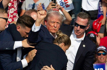 銃撃直後、右手を上げるトランプ氏=2024年7月、米東部ペンシルベニア州バトラー(AFP時事)