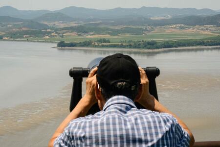 南北を隔てる非武装地帯の北朝鮮側を双眼鏡で観察する観光客=6月12日、韓国・坡州市(AFP時事)