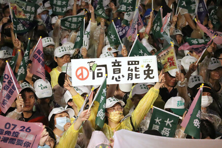 台湾立法委員(国会議員)のリコール推進団体が開いた集会で「罷免に同意」と書かれたプラカードを掲げる参加者=24日、台北市