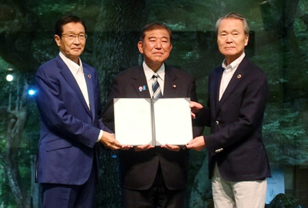 経団連の夏季フォーラムで、石破茂首相(中央)に総括文書を手渡す筒井義信会長(右)=25日午後、長野県軽井沢町