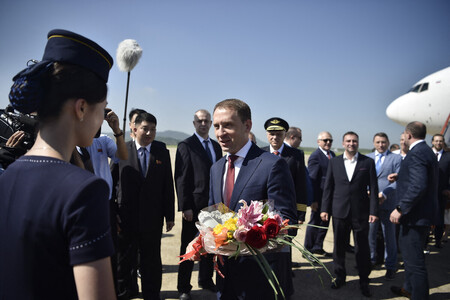 ２８日、北朝鮮・平壌の空港に到着し、歓迎を受けるロシアのコズロフ天然資源環境相（中央）（ＡＦＰ時事）
