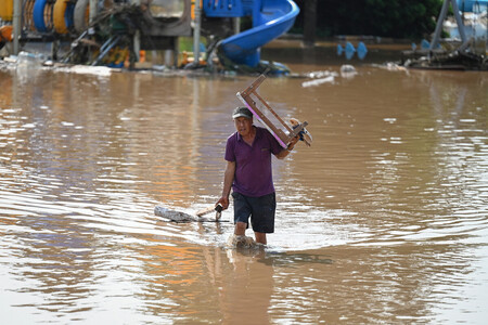 ２８日、北京郊外で豪雨により冠水した場所を歩く住民（ＡＦＰ時事）