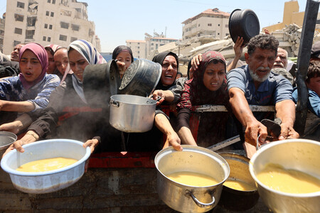 パレスチナ自治区ガザ北部ガザ市で、食料の配給に集まる住民=27日(AFP時事)