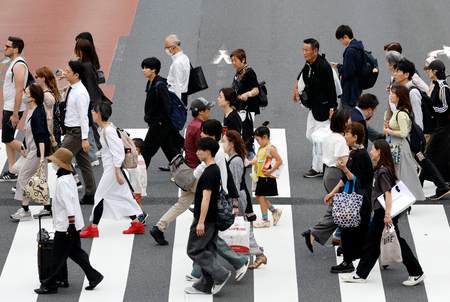 東京・新宿地区の横断歩道を渡る歩行者=6月4日(EPA時事)
