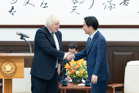 ５日、台北の台湾総統府で頼清徳総統（右）と握手するジョンソン元英首相（総統府提供）