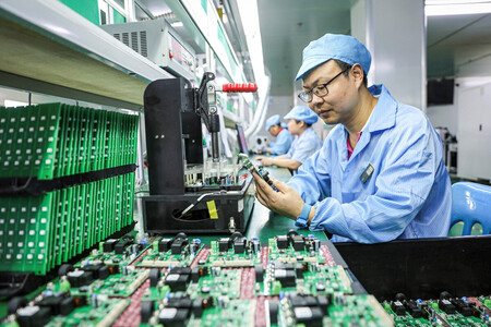 電気自動車(EV)用充電ステーションの製造ラインで働く従業員=7月9日、中国江西省(AFP時事)