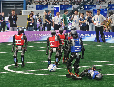 「世界人型ロボット運動会」のサッカーの試合。人型ロボットがボールを奪い合った=15日、中国・北京市