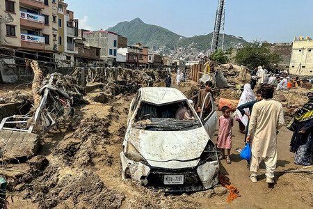 パキスタンの洪水で流された車＝１６日、北西部カイバル・パクトゥンクワ州（ＡＦＰ時事）