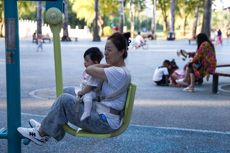 公園で子供を抱く女性＝７月３０日、北京（ＥＰＡ時事）