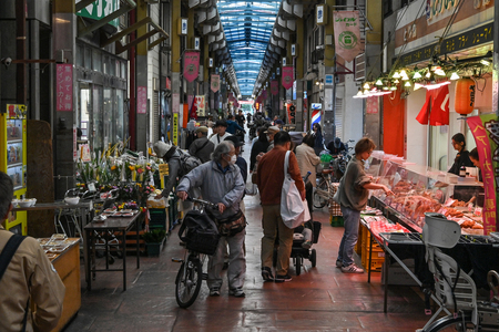東京・三ノ輪地区のアーケード商店街を歩く住民ら(AFP時事)
