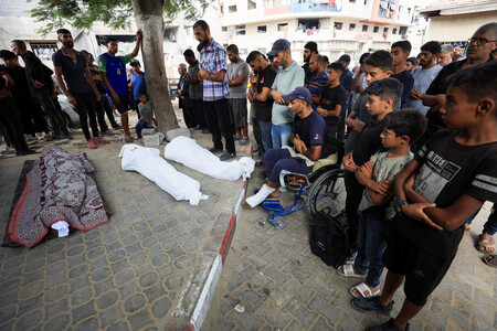 ２１日、パレスチナ自治区ガザの中心都市ガザ市で、イスラエルの攻撃により死亡した住民を悼む人々（ロイター時事）