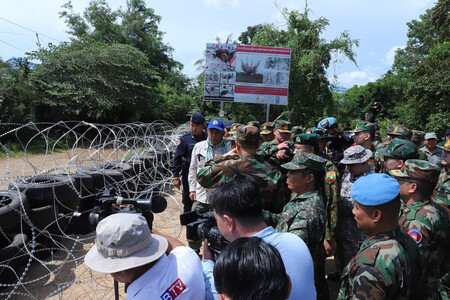 タイ軍が設置した有刺鉄線をカンボジア側から視察する東南アジア諸国連合(ASEAN)各国の駐在武官ら=14日、北西部バンテアイミアンチェイ州(カンボジア情報省のSNSより・時事)
