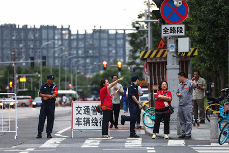 軍事パレードの予行演習を前に警備に当たるボランティアら=23日、中国・北京(EPA時事)