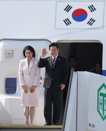 東京・羽田空港から米国へ出発する韓国の李在明大統領(右)と金恵景夫人=24日午後