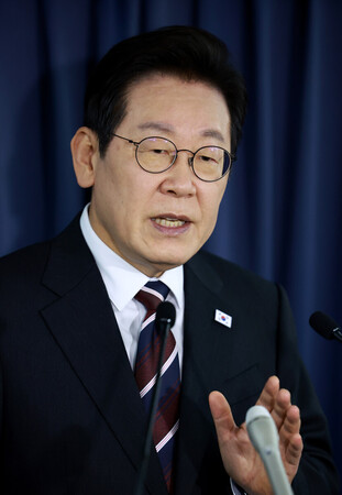 24日、米国に向かう大統領専用機内で記者団の質問に答える韓国の李在明大統領(EPA時事)