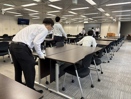 研修会場の設営業務に従事する野村かがやきの社員ら＝７月１７日、東京都千代田区