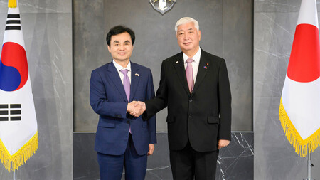 8日、ソウルで握手する中谷元防衛相(右)と韓国の安圭伯国防相(韓国国防省提供・時事)