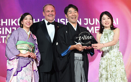 最優秀賞を受賞し、トロフィーを受け取る山梨銘醸の北原対馬社長（右から２人目）＝９日、ロンドン