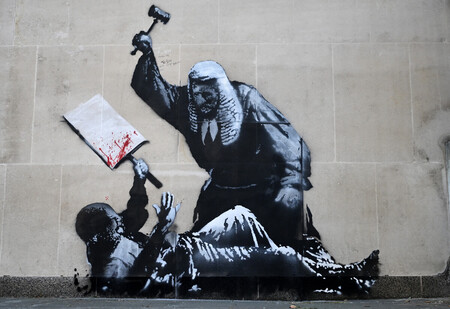 英王立裁判所の建物の壁に描かれた、正体不明の路上芸術家バンクシーの絵＝９日、ロンドン（ＡＦＰ時事）