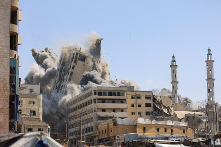 １５日、パレスチナ自治区ガザの中心都市ガザ市で、イスラエル軍の空爆を受けて倒壊する建物（ＡＦＰ時事）
