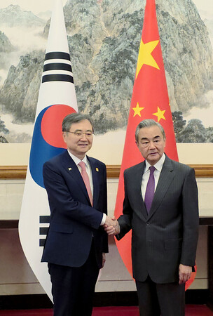 １７日、北京で会談を前に握手する中国の王毅共産党政治局員兼外相（右）と韓国の趙顕外相（ＥＰＡ時事）