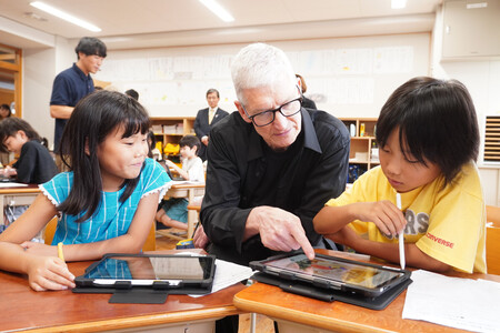 京都市立御所東小学校を訪れ、米アップルのiPadを使った授業を視察するティム・クック最高経営責任者(CEO、中央)=26日午後、同市上京区
