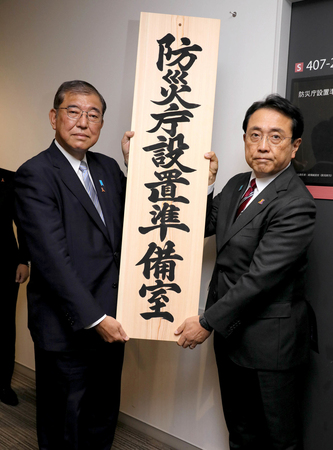 防災庁設置準備室の看板を掛ける石破茂首相（左）と赤沢亮正担当相＝２０２４年１１月１日、東京都千代田区
