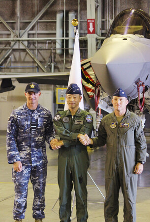 最新鋭ステルス戦闘機F35Aの前で握手する航空自衛隊の谷嶋正仁・航空総隊司令官(中央)と米豪空軍の指揮官=30日午後、青森県三沢市の空自三沢基地