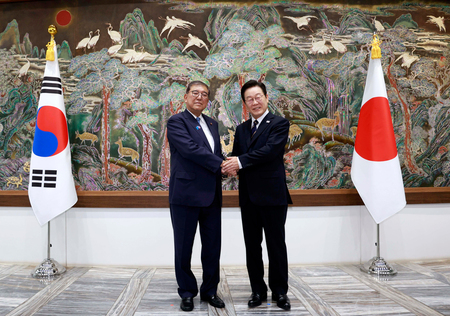 韓国の李在明大統領(右)と握手する石破茂首相=9月30日、韓国・釜山(EPA時事)