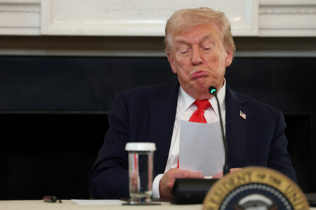8日、ホワイトハウスで、ルビオ米国務長官から手渡されたメモを読むトランプ大統領=ワシントン(AFP時事)