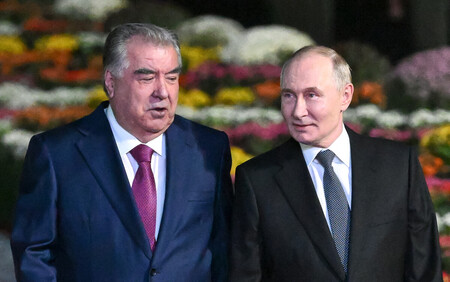 8日、タジキスタンの首都ドゥシャンベの空港で、ラフモン大統領(左)の出迎えを受けるロシアのプーチン大統領(AFP時事)