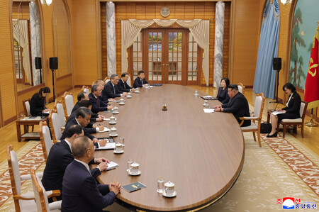 9日、平壌で会談する北朝鮮の金正恩朝鮮労働党総書記(右手前)と中国の李強首相(左手前から6人目)(朝鮮通信・時事)