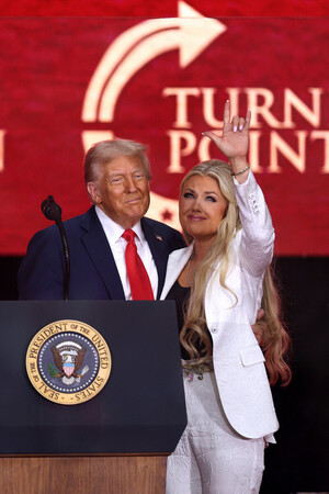 トランプ米大統領(左)と、射殺された保守活動家チャーリー・カーク氏の妻エリカ氏=9月21日、西部アリゾナ州グレンデール(AFP時事)